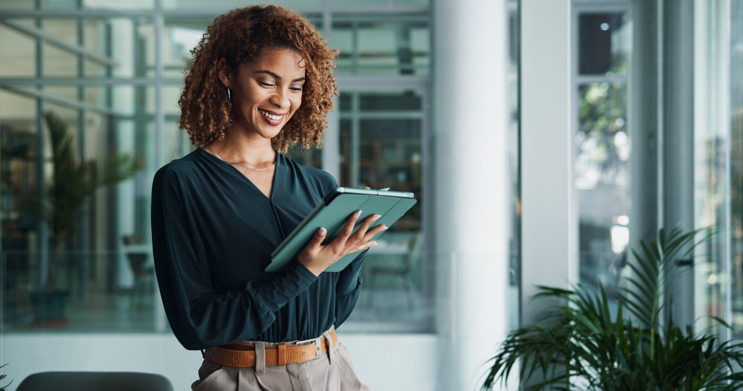Tablette, femme créative et souriante avec portfolio, recherche ou lecture d'actualités pour publication dans le bureau d'une startup. Technologie numérique, gestion et planification de projets d'entreprise, feedback et résolution de problèmes.