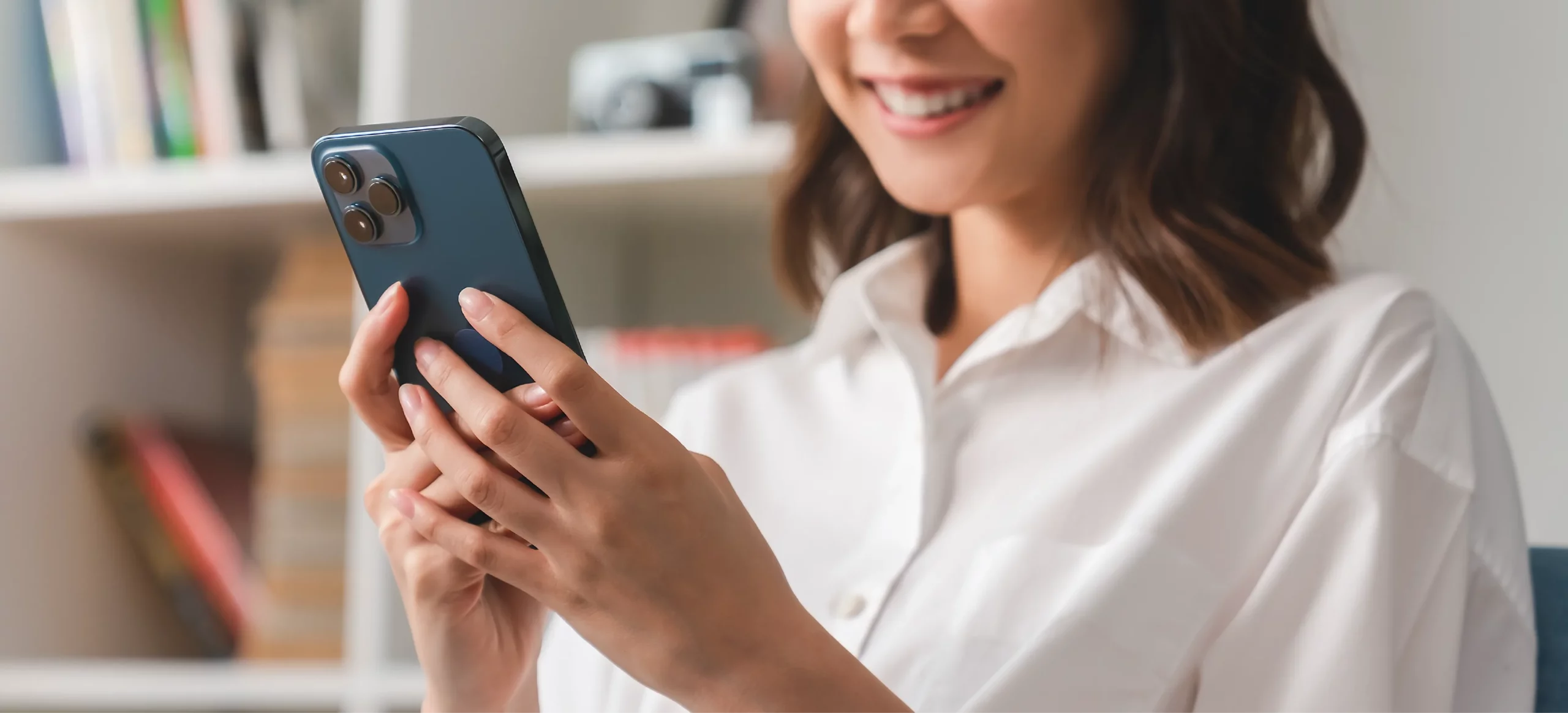 Femme qui consulte son smartphone en souriant