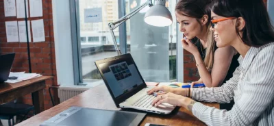 Deux femmes qui consultent un site internet sur ordinateur